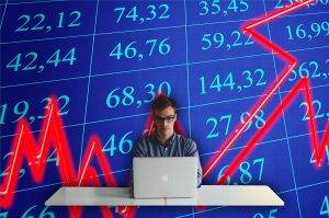 Man typing on laptop with a spreadsheet depicting positive growth and a large red upwards arrow in the background behind him.